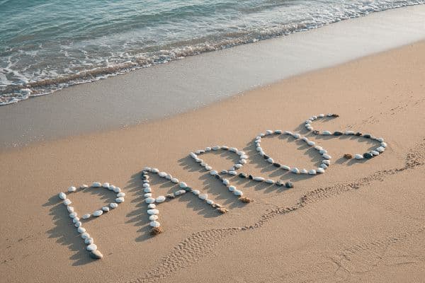 Paros written with white stones on sandy beach by the sea